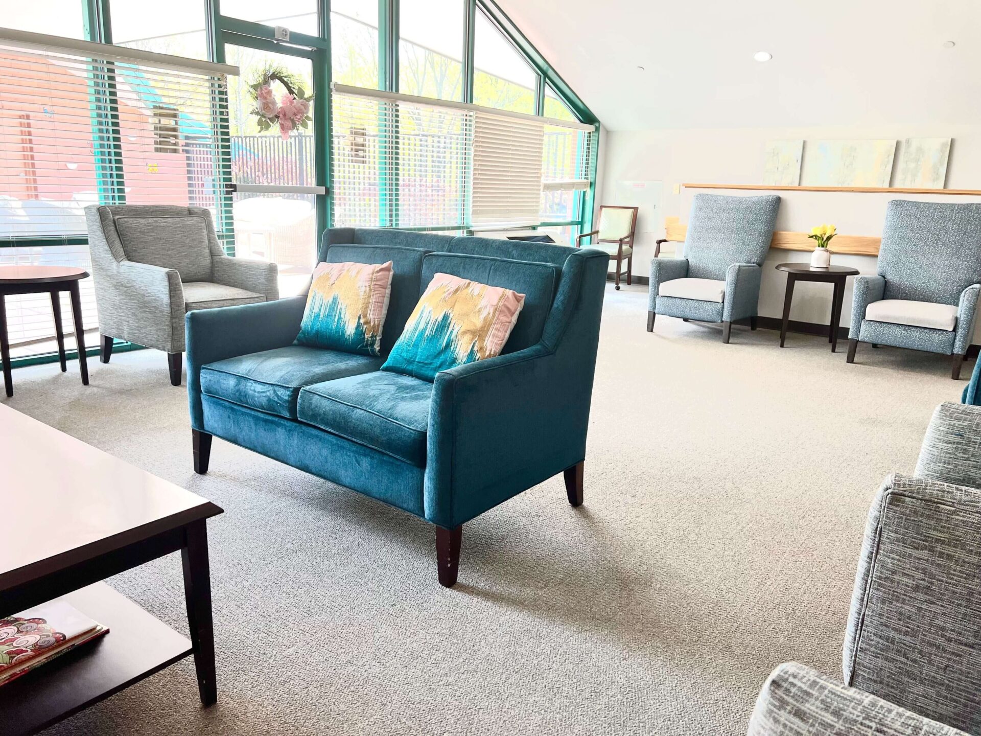 Bright seating area with modern chairs and sofa in a senior living community common room.