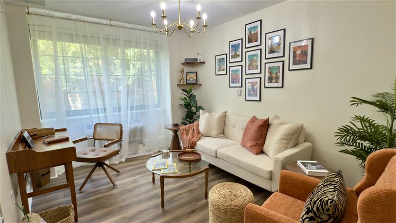 Image (2) living room with comfortable couches, an armchair, a desk, and a gallery wall.