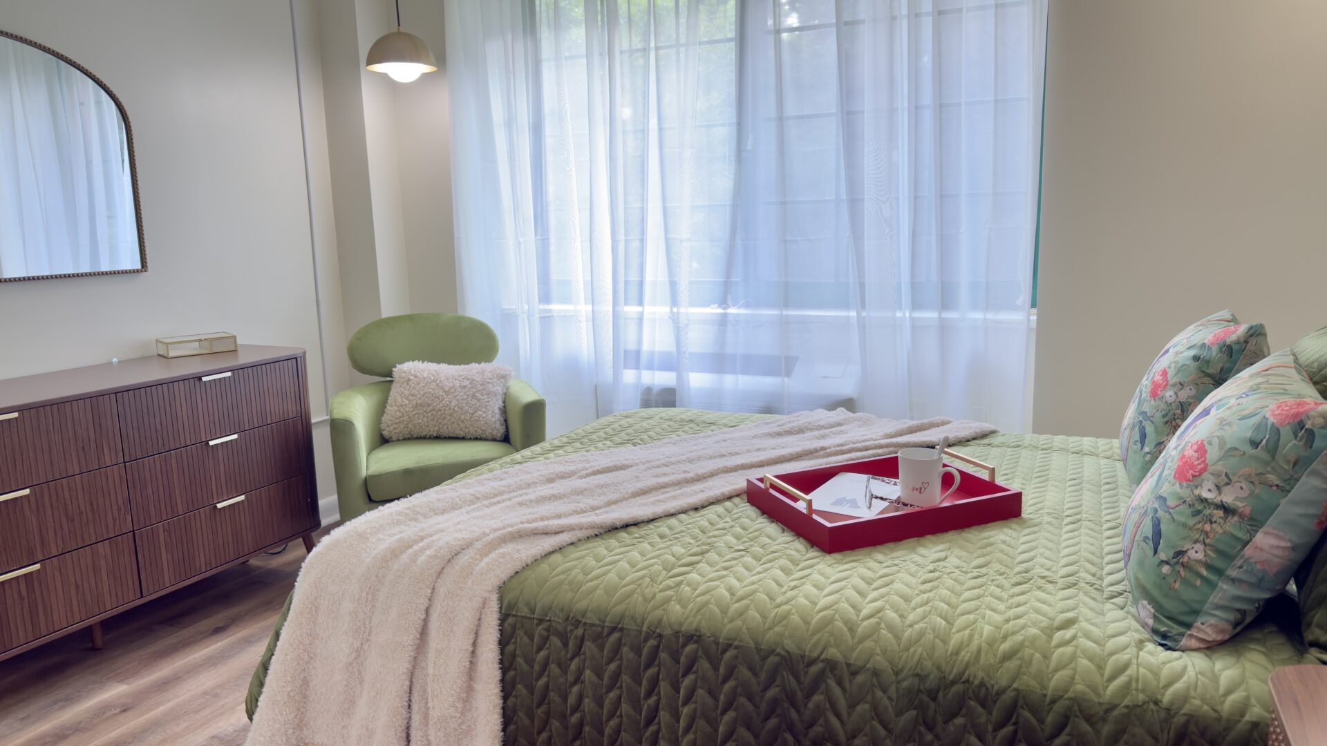 bedroom with green accents and a large dresser